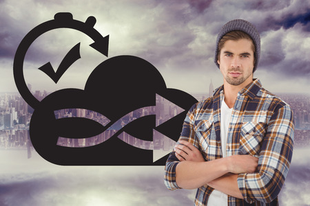 Portrait of confident hipster with arms crossed against room with large window looking on cityの写真素材