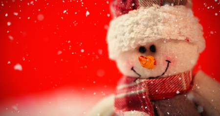 Snow falling against close-up of snowmanの写真素材