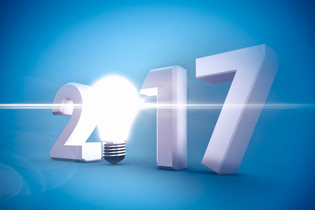 2017 with glowing light bulb over white background against blue vignette backgroundの写真素材