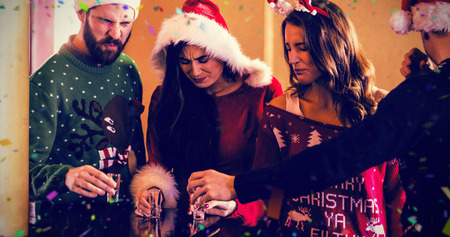 Festive friends having shots against flying coloursの写真素材