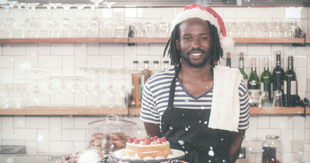 Happy hipster worker posing with Christmas hat against snow fallingの写真素材