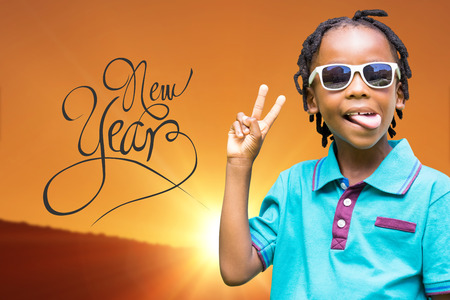 Child making wince against scenic view of landscape against orange skyの写真素材