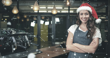 Portrait of barista wearing santa hat against snow fallingの写真素材