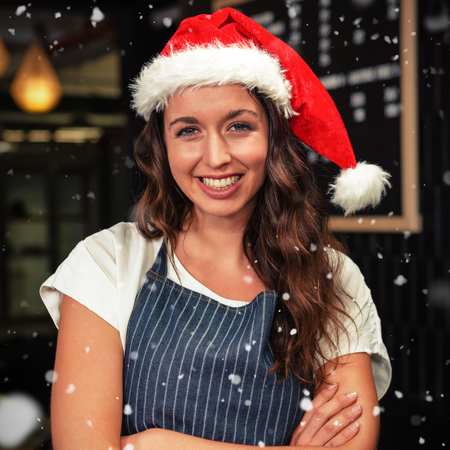 Portrait of barista wearing santa hat against snow fallingの写真素材