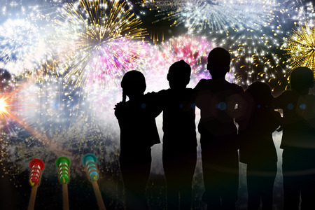 Silhouette children standing against colourful fireworks exploding on black backgroundの写真素材