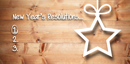 New years resolution list against christmas decorations over wood