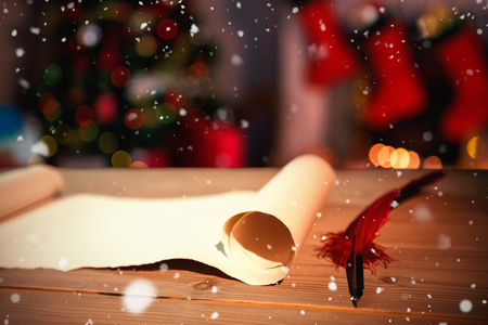 Snow falling against old blank scroll paper and quillの写真素材