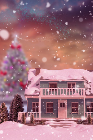 Snow covered house against fir tree in snowy landscapeの写真素材