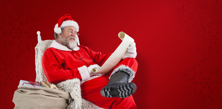 Santa Claus reading wish list on scroll against white background against red snowflake backgroundの写真素材