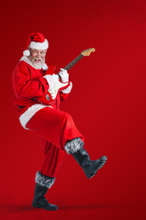 Cheerful Santa Claus playing guitar against red snowflake backgroundの写真素材