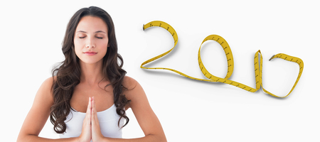Pretty brunette doing yoga against white background with vignette