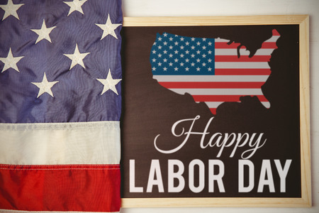 Poster of happy labor day text against american flag on chalkboardの写真素材