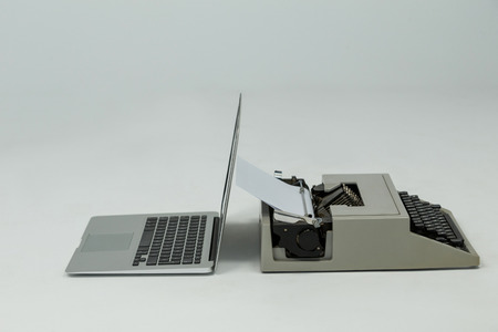Laptop and typewriter on grey backgroundの写真素材