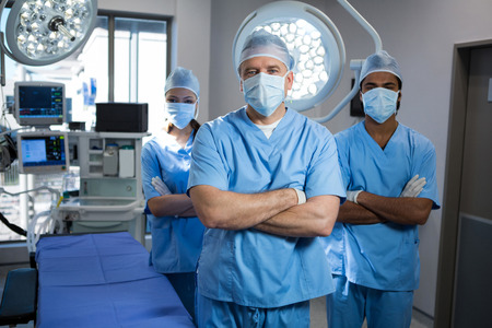 Portrait of a surgeons standing with arms crossed in operation theaterの写真素材
