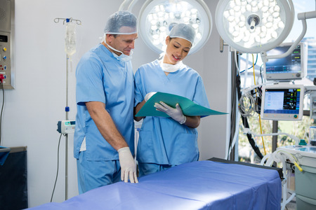 Surgeons discussing over file in operation theater