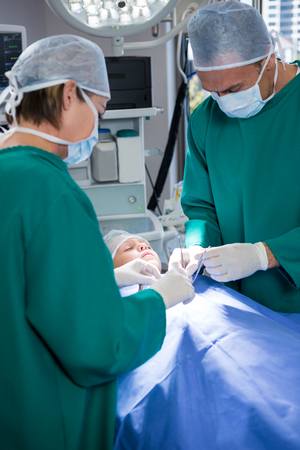 Surgeons operating patient in operation theaterの写真素材