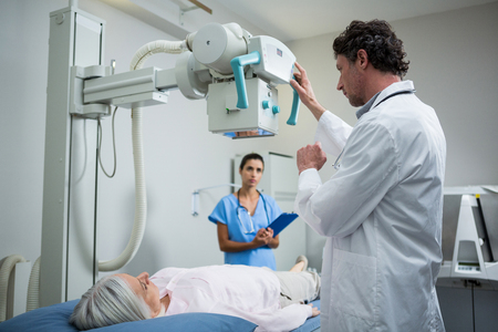 Doctors performing a x-ray test on patient chest in hospitalの写真素材