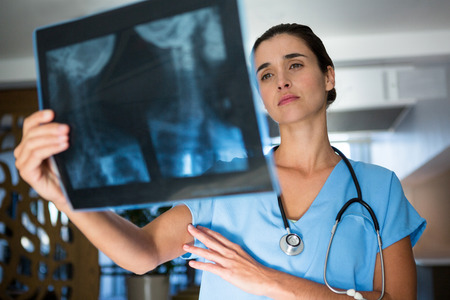 Female surgeon examining an x-ray report in hospital