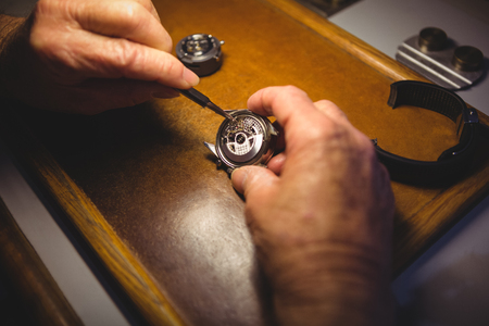 Horologist repairing a watch in the workshopの写真素材