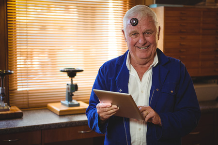 Portrait of horologist using digital tablet in workshopの写真素材