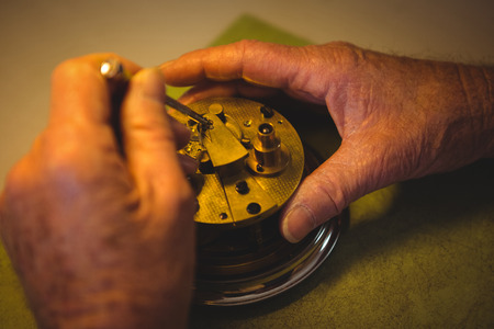 Horologist repairing a watch in the workshopの写真素材