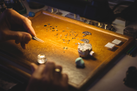 Horologist repairing a watch in the workshopの写真素材