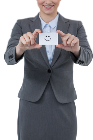 Businesswoman holding visitor card with smiley against white backgroundの写真素材
