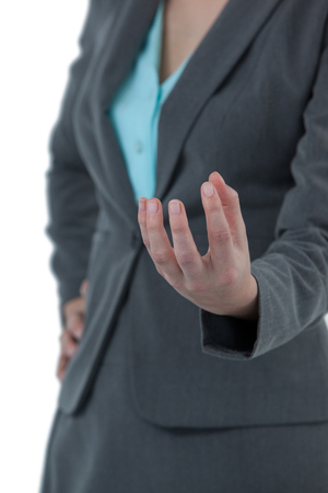 Mid section of businesswoman gesturing against white backgroundの写真素材