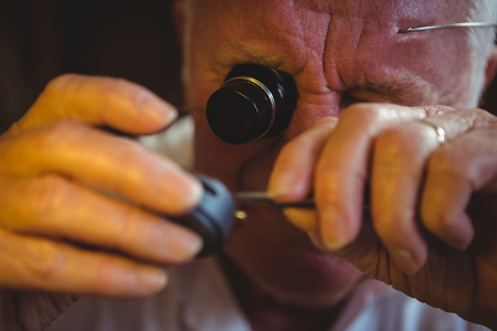 Horologist repairing a watch in the workshopの写真素材