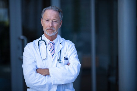 Portrait of male surgeon standing with arms crossed at the hospitalの写真素材