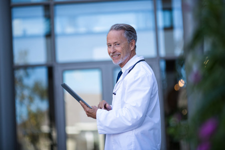 Portrait of doctor using digital tablet in hospitalの写真素材