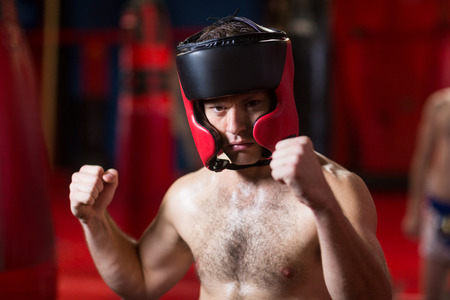 Portrait of confident boxer performing boxing stance in fitness studioの写真素材