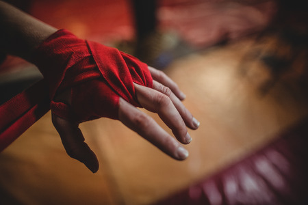 Hand of female boxer wearing red strap on wristの写真素材