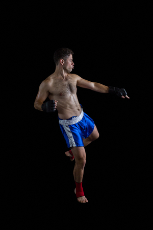 Boxer performing boxing stance against black backgroundの写真素材