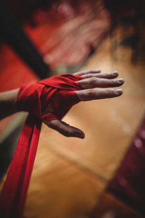 Hand of female boxer wearing red strap on wristの写真素材