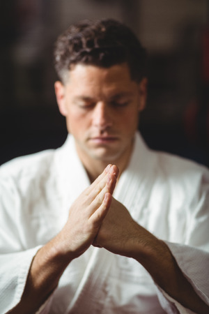 Karate player performing karate stance in fitness studioの写真素材