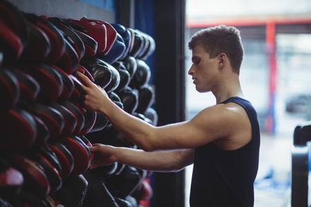 Kick boxer choosing gloves in fitness studioの写真素材