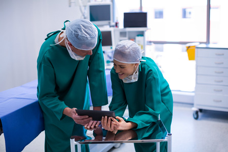 Surgeons using digital tablet in operation theater of hospitalの写真素材
