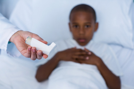 Doctor holding asthma inhaler in hospitalの写真素材