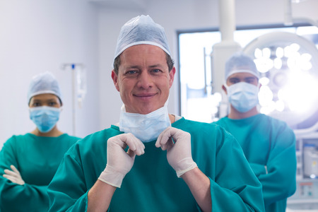 Team of surgeons wearing surgical mask in operation theater of hospital