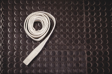 Rolled -up karate white belt on metallic backgroundの写真素材