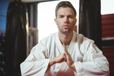 Karate player performing karate stance in fitness studioの写真素材