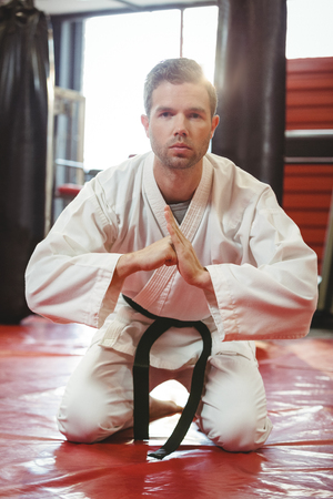 Karate player performing karate stance in fitness studioの写真素材