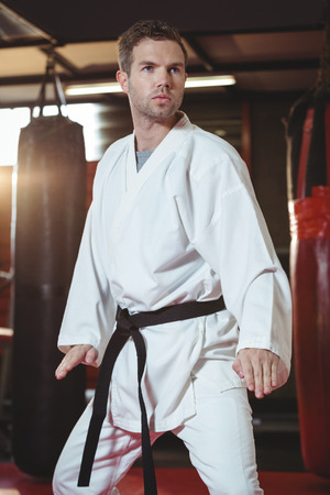 Karate player performing karate stance in fitness studioの写真素材