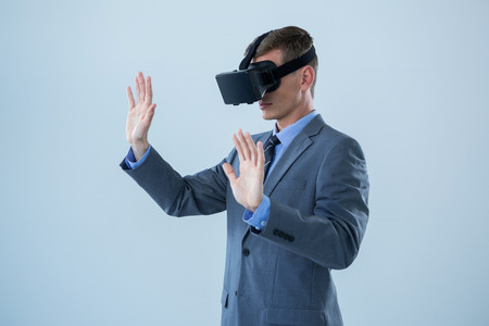 Businessman using virtual reality headset  against white backgroundの写真素材