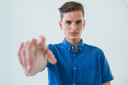 Portrait of man touching an invisible screen against white background