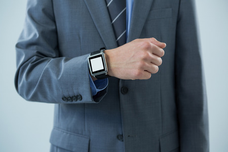 Mid section of businessman showing his smartwatchの写真素材