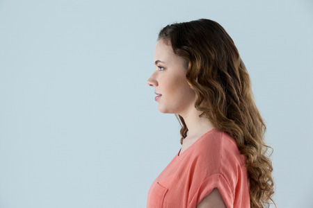 Profile of beautiful woman against grey backgroundの写真素材