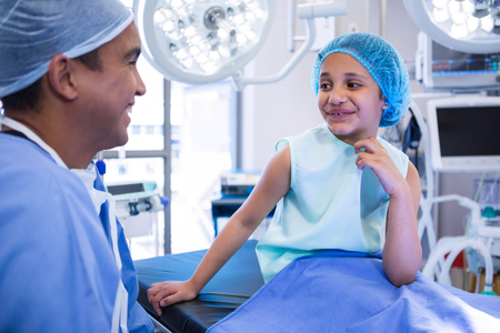 Doctor interacting with patient in operation room at hospitalの写真素材