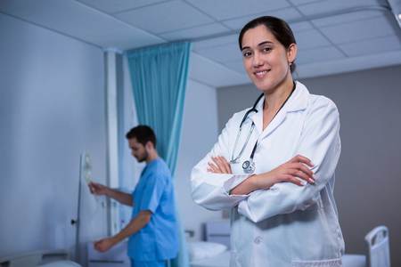 Portrait of doctor standing with arms crossed at hospitalの写真素材